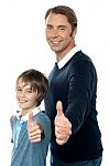 Confident Father And Son Duo Gesturing Thumbs Up Stock Photo