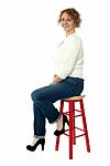 Confident Senior Woman Resting On Stool Stock Photo