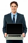 Corporate Executive Showing Laptop To Camera Stock Photo