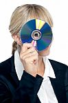 Corporate Lady Looking Through Compact Disc Hole Stock Photo