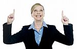 Corporate Lady Pointing Upwards With Both Hands Stock Photo