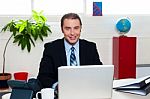 Corporate Leader Sitting In Front Of His Laptop Stock Photo