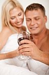 Couple Drinking Wine In Bed Stock Photo