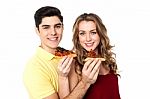 Couple Enjoying Pizza Slices Together Stock Photo