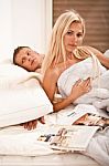 Couple In Bed With Magazine Stock Photo