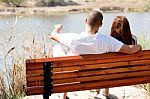 Couple Sitting At Lake Side Stock Photo