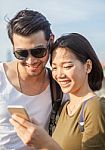 Couples Younger Asian Man And Woman Watching On Smart Phone Stock Photo