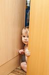 Curious Cute Baby Boy Looking Through Ajar Door Stock Photo