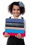 Cute School Girl Carrying Stack Of Books Stock Photo