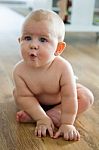 Cute Smiling Baby Sitting At Home Stock Photo