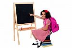 Cute Smiling Student Pointing At Blank Chalkboard Stock Photo