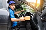 Delivery Messenger Man With Cardboard Box  Outside The Warehouse Stock Photo