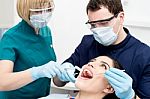 Dentist Examining Gums Of Patient Stock Photo