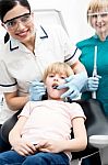 Dentist Operating Teeth  Of Girl Child Stock Photo