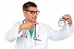 Doctor Pointing At Alarm Clock Stock Photo