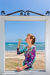 Drinking Woman In Window At Sea Stock Photo