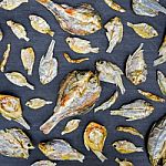 Dry Fish With Sunny On Black Wooden Floor Stock Photo