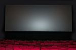 Empty Seat On Row In Thearter With Movie Screen Stock Photo