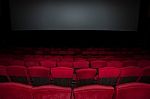 Empty Seat On Row In Thearter With Movie Screen Stock Photo