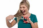 Excited Blonde Girl About To Trim Her Hair In Fun Stock Photo