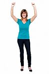 Excited Woman In Celebration Mood With Raised Arms Stock Photo