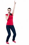 Excited Young Woman Pointing Upwards Stock Photo