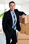 Executive With His Hand Placed On Pile Of Cardboard Cartons Stock Photo