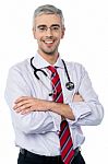 Experienced Doctor With Arms Crossed Stock Photo