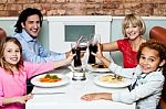 Family Raising Their Glasses Before Eating Stock Photo