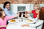 Family Raising Their Glasses Before Eating Stock Photo