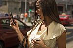 Fashionable Young Brunette Laughs Into Phone Stock Photo