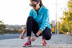 Female Athlete Tying Laces For Jogging Stock Photo