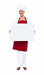 Female Chef Displaying Blank White Ad Board Stock Photo