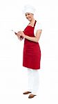 Female Cook Writing On Clipboard Stock Photo