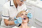 Female Dentist Inspecting Teeth Of Patient Stock Photo