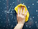 Female Hand Washes Tihe Tile On The Wall Stock Photo