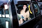 Female Passenger Reading Newspaper Inside Taxi Stock Photo