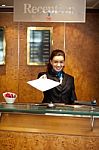 Female Receptionist Giving Paper Stock Photo