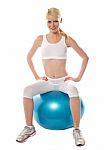 Female Sitting On Exercise Ball Stock Photo