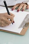 Female Writing On Clipboard Stock Photo