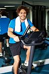 Fitness Man Riding A Static Bike Inside Gym Stock Photo