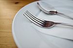 Fork And Spoon With White Plate On Wood Table Stock Photo