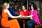 Four Friends Enjoying Dinner At A Restaurant Stock Photo