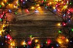 Frame Of The Colorful Christmas Festoon On The Wooden Board Stock Photo