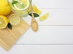 Fresh Lemon In Water, Lemonade And Lemon Slice On White Wood Bac Stock Photo