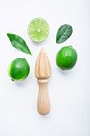 Fresh Limes And Wooden Juicer On White Background. Top View With Stock Photo