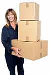 Friendly Delivery Woman With Three Packed Cartons Stock Photo