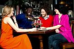 Friends Enjoying Dinner At A Restaurant Stock Photo