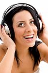 Front View Of Smiling Female Enjoying Music Against White Background Stock Photo