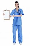 Full Length Of Young Nurse Pointing Blank Clipboard Stock Photo